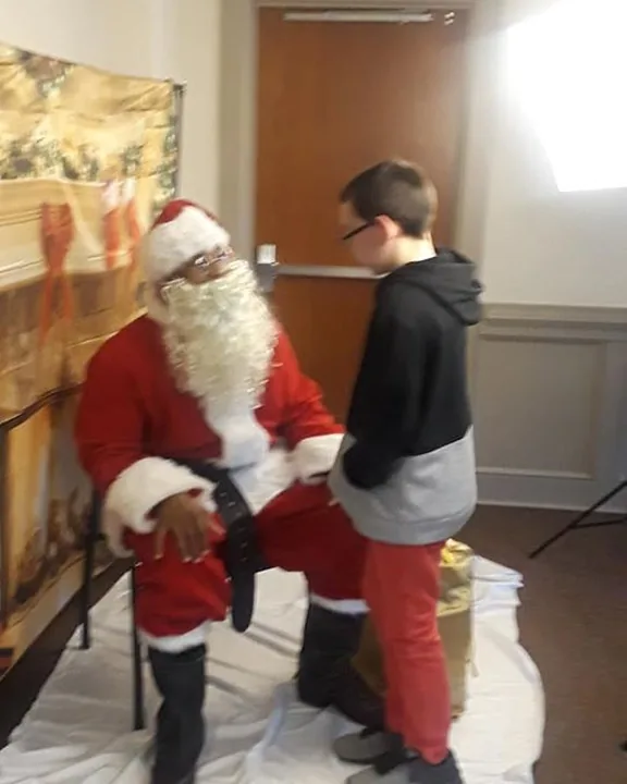 Santa greeting a young person at the C.A.N. Christmas extravaganza