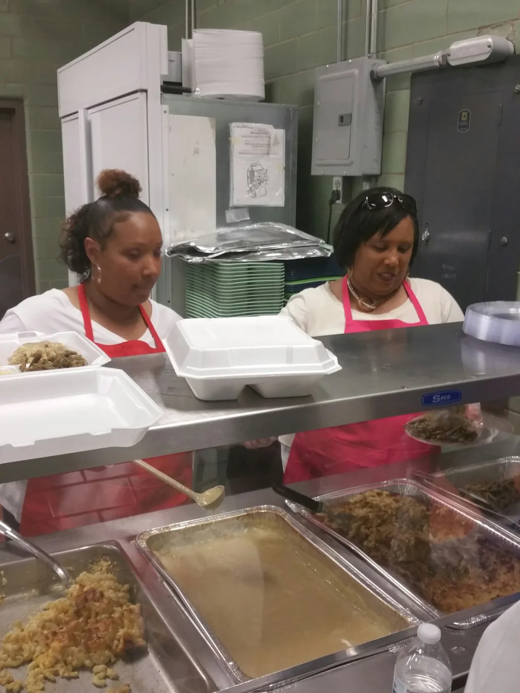 Volunteers serving hot food along the line at the Thanksgiving dinner
