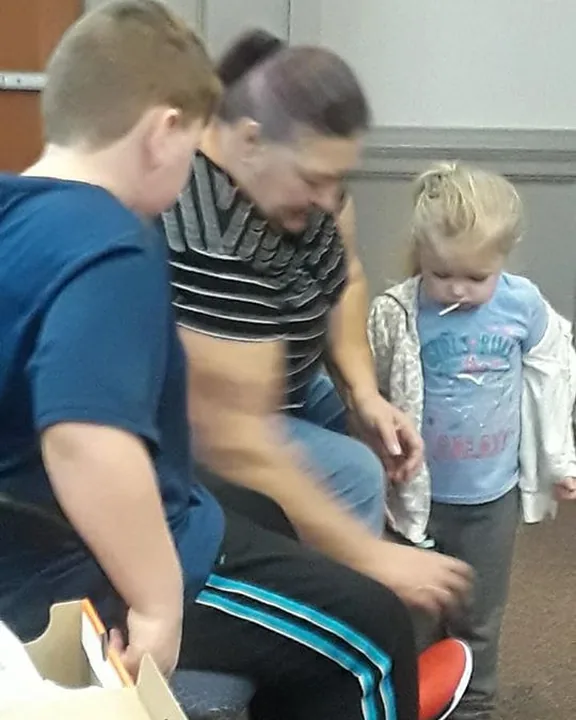 A child being fitted for brand new shoes at the Santa's Feet give-away