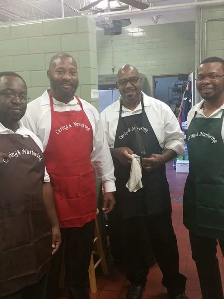 Three C.A.N. volunteers in aprons in the kitchen